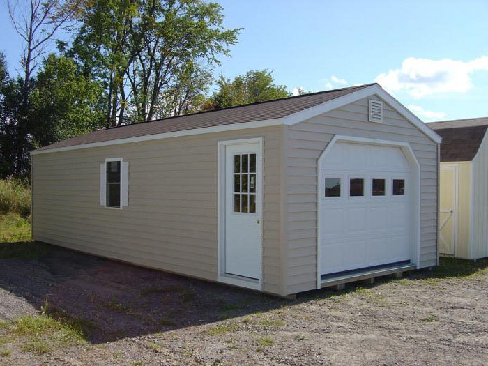 Tan wood A-frame garage with a white roll-up garage door and side window.