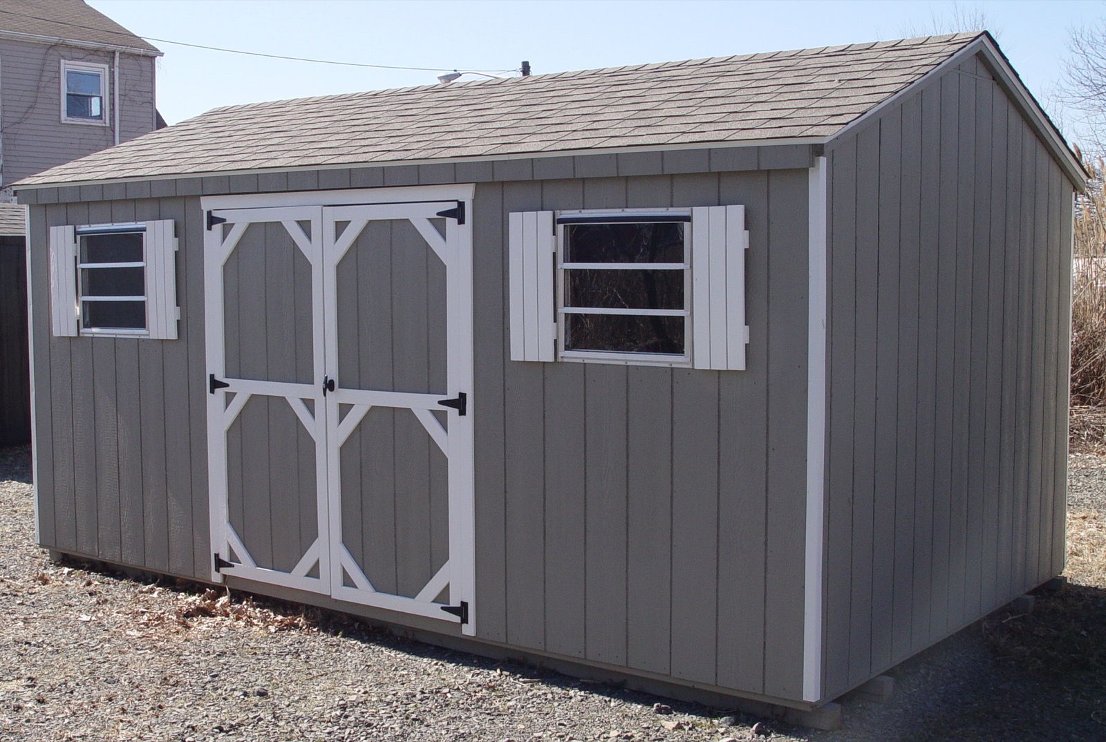 Grey wood A-frame shed with a vented gable and white trim.