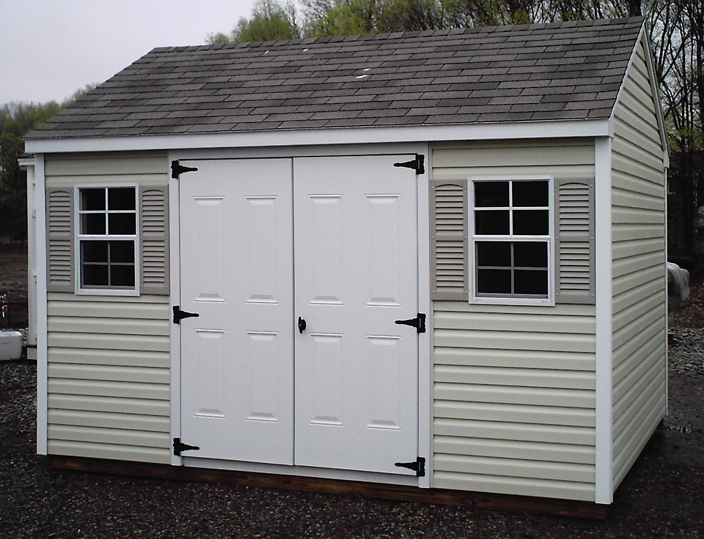 Vinyl-sided A-frame storage shed with double doors and shutters.